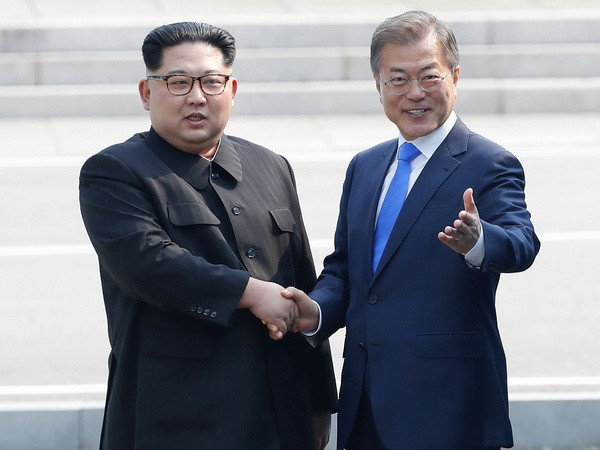 Tổng thống Hàn Quốc Moon Jae-in (phải) và Nhà lãnh đạo Triều Tiên Kim Jong-un bắt tay hữu nghị tại làng đình chiến Panmunjom. (Nguồn: EPA-EFE/TTXVN) Nhà lãnh đạo Triều Tiên Kim Jong-un kêu gọi chấm dứt đối đầu ảnh 1
