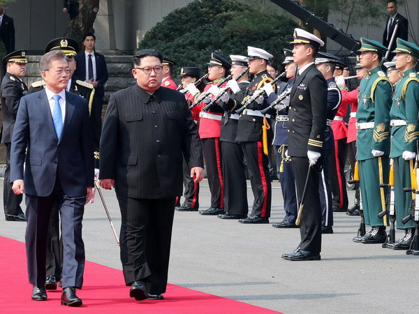 Tổng thống Hàn Quốc Moon Jae-in (trái, phía trước) và Nhà lãnh đạo Triều Tiên Kim Jong-un (phải, phía trước) duyệt đội danh dự tại quảng trường ở làng đình chiến Panmunjom. (Nguồn: YONHAP/TTXVN) Nhật Bản hy vọng liên Triều sẽ thảo luận nghiêm túc về hạt nhân ảnh 1