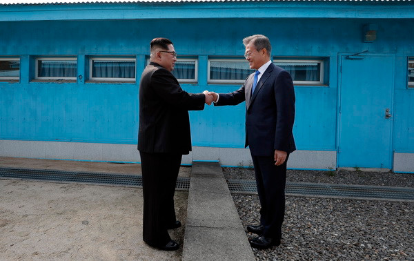 Tổng thống Hàn Quốc Moon Jae-in (phải) đón Nhà lãnh đạo Triều Tiên Kim Jong-un ở đường phân định ranh giới giữa hai miền tại làng đình chiến Panmunjom. (Nguồn: TTXVN) Tiết lộ nội dung cuộc gặp thượng đỉnh liên Triều lịch sử ảnh 1