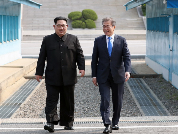 Nhà lãnh đạo Triều Tiên Kim Jong-un (trái) và Tổng thống Hàn Quốc Moon Jae-in bắt tay hữu nghị tại làng đình chiến Panmunjom. (Nguồn: YONHAP/TTXVN) Hàn Quốc nhận định đối thoại đã diễn ra chân thành và thẳng thắn ảnh 1