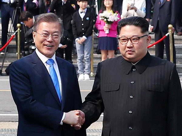 Tổng thống Hàn Quốc Moon Jae-in (trái) bắt tay hữu nghị Nhà lãnh đạo Triều Tiên Kim Jong-un (phải) tại làng đình chiến Panmunjom. (Nguồn: YONHAP/TTXVN) Chính thức bắt đầu cuộc gặp thượng đỉnh liên Triều lịch sử ảnh 1