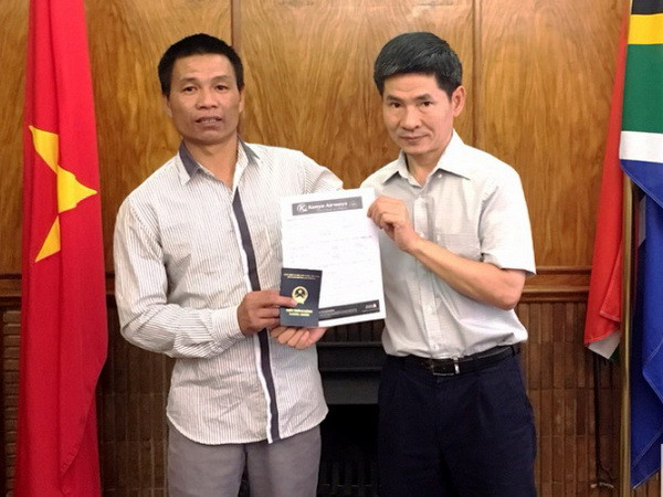 Đại diện Đại sứ quán trao vé máy bay và giấy thông hành cho anh Nguyễn Văn Thanh. (Nguồn: Đại sứ quán Việt Nam tại Nam Phi) Đại sứ quán Việt Nam ở Nam Phi hỗ trợ người Việt Nam gặp nạn ảnh 1