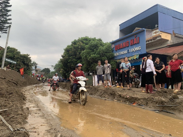 Bùn đất theo lũ trôi về tràn ngập trên Quốc lộ 279. (Ảnh Hồng Ninh/TTXVN) Thủ tướng yêu cầu các địa phương theo dõi chặt chẽ diễn biến mưa lũ ảnh 1