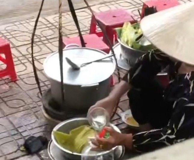 Bà H.T.T đổ nước thừa của khách vào bình. (Ảnh cắt từ clip) Xử lý nghiêm trường hợp bán hàng rong đổ nước dùng thừa vào nồi ảnh 1