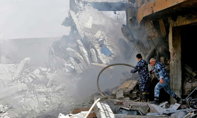 Binh sĩ Syria kiểm tra mức độ thiệt hại tại trung tâm nghiên cứu khoa học ở Barzeh (Nguồn: AFP) Tranh cãi về số liệu tên lửa liên quân Mỹ-Anh-Pháp bị Syria bắn hạ ảnh 1
