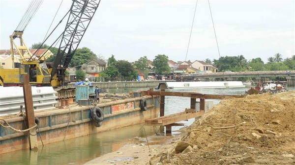 Thi công phần móng kè chống sạt lở bờ sông gây nguy hại đến phố cổ. (Ảnh: Hữu Trung/TTXVN) Xây bờ kè bảo vệ phố cổ Hội An trước biến đổi khí hậu ảnh 1