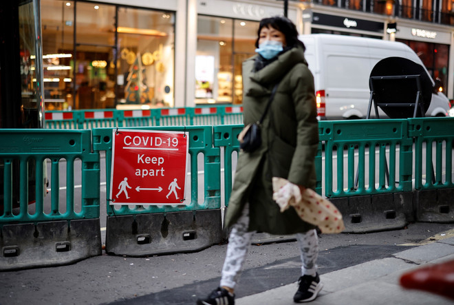 Người dân đeo khẩu trang phòng lây nhiễm COVID-19 tại London, Anh. (Ảnh: AFP/TTXVN) Dịch COVID-19: London có một mùa Giáng sinh khác lạ ảnh 2