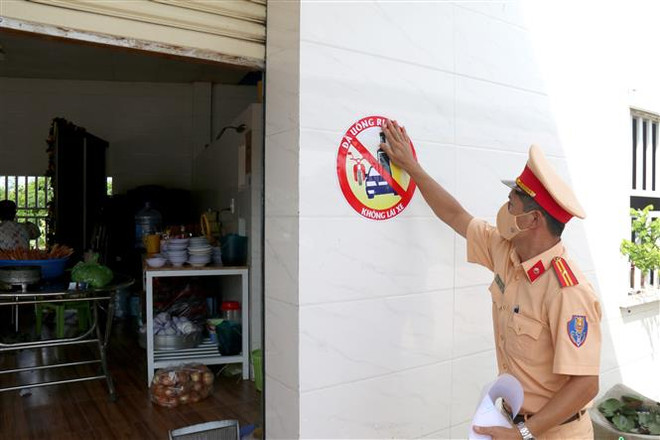 Dán Logo decal với nội dung Đã uống rượu bia - Không lái xe tại nhà hàng, quán ăn trên địa bàn thành phố Phan Thiết. (Ảnh: Nguyễn Thanh/TTXVN) Thực hiện cấm lái xe khi uống rượu bia - Không 'đánh trống bỏ dùi' ảnh 1