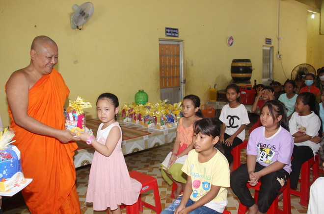 Đại đức Thạch Dương Trung, Trụ trì chùa Moniserey Sophon Cosđôn (xã Vĩnh Phú Tây, huyện Phước Long, tỉnh Bạc Liêu) động viên và tặng dụng cụ học tập cho học sinh tham gia khóa học hè tại chùa. (Ảnh: Chanh Đa/TTXVN) ttxvn_1706_Khmer (2).jpg