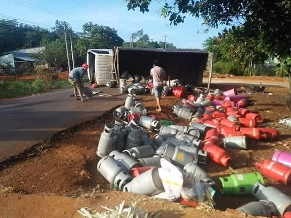 Xe tải chở gas bị lật làm hàng chục bình gas rơi xuống đường ảnh 1