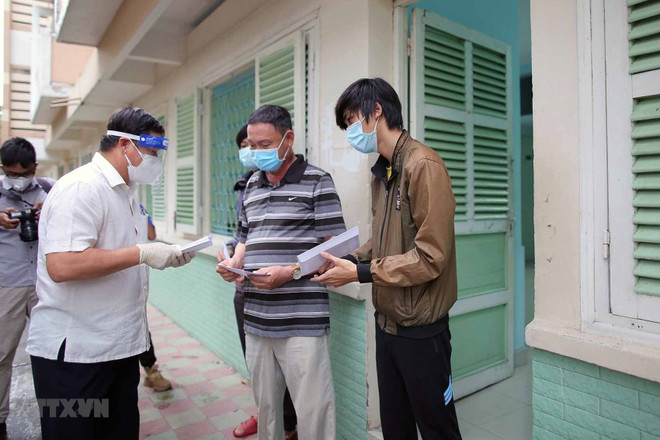 Trao tiền hỗ trợ cho người dân gặp khó khăn. (Ảnh: Thanh Vũ/TTXVN) TP.HCM: Tăng cường giám sát đảm bảo chính sách an sinh cho người dân ảnh 2