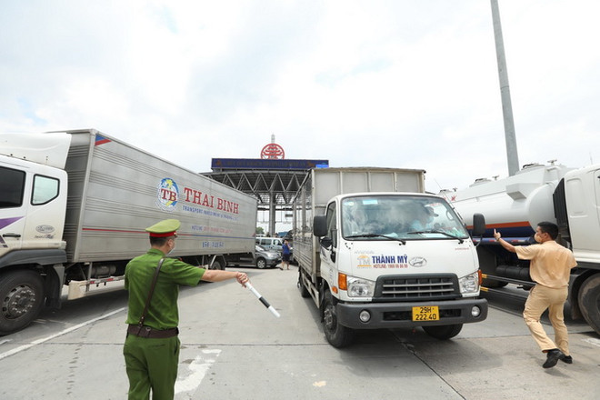 Lực lượng chức năng hướng dẫn các phương tiện quay đầu tại trạm thu phí Pháp Vân-Cầu Giẽ. (Ảnh: Minh Quyết/TTXVN) Hà Nội xây dựng phương án mở lại dịch vụ vận tải theo từng giai đoạn ảnh 1
