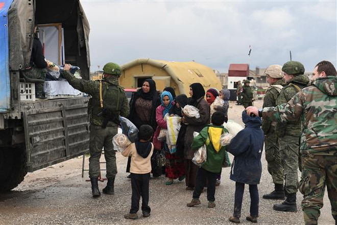 Phát hàng cứu trợ cho người dân Syria ở Abu Duhur, tỉnh Idlib. (Ảnh: AFP/TTXVN) Chính phủ Syria đặt cược vào người giàu để khôi phục nền kinh tế ảnh 1