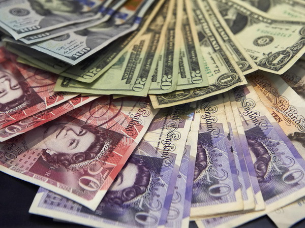 Đồng bảng Anh và USD. (Ảnh: AFP/TTXVN) Tài chính công của Anh có thể bị thâm hụt đến gần 59 tỷ bảng ảnh 1