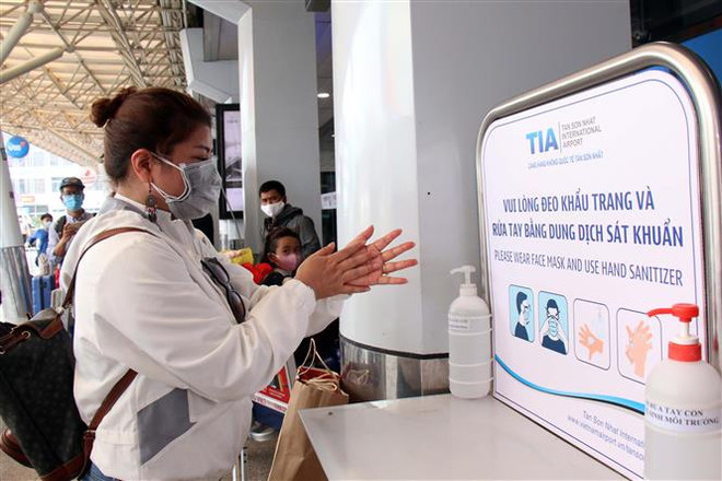 Hành khách rửa tay sát khuẩn trước khi vào khu vực làm thủ tục tại sân bay Tân Sơn Nhất. (Ảnh: Tiến Lực/TTXVN) Thêm 4 ca mắc mới là đồng nghiệp nhân viên sân bay Tân Sơn Nhất ảnh 1