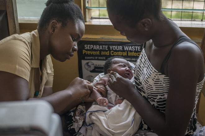 Nhân viên y tế tiêm vaccine ngừa sốt rét cho trẻ em tại Cape Coast, Ghana ngày 30/4/2019. (Ảnh: AFP/TTXVN) Vaccine mới phòng bệnh sốt rét đạt hiệu quả thử nghiệm cao ảnh 1