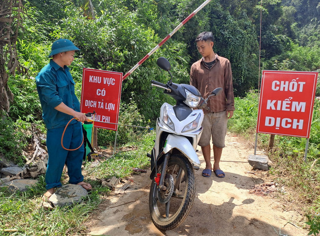 Triển khai phun hóa chất vệ sinh sát khuẩn các phương tiện ra, vào khu vực có ổ dịch. (Ảnh: Đức Thọ/TTXVN) ttxvn_khu khuan dich ta chau phi ha Giang.jpg