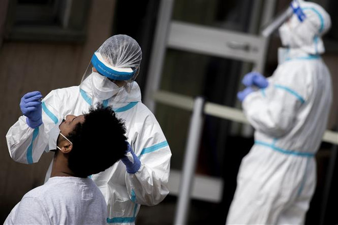 Nhân viên y tế lấy mẫu dịch xét nghiệm COVID-19 cho người dân tại Rome, Italy. (Ảnh: AFP/TTXVN) Châu Âu tiếp tục căng thẳng vì đại dịch COVID-19 ảnh 2