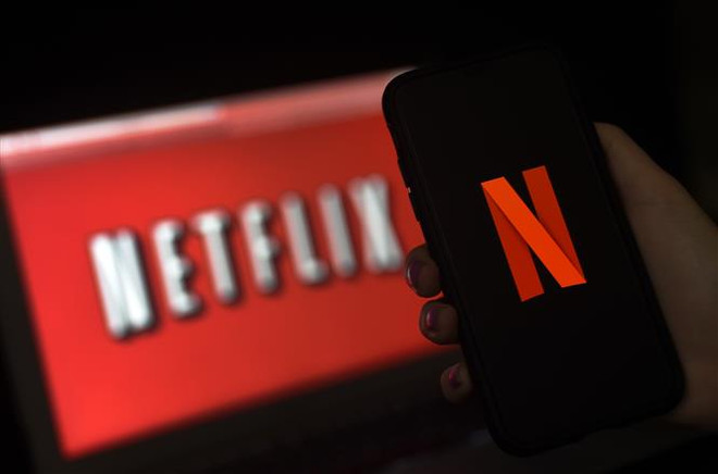 Biểu tượng Netflix trên màn hình máy tính và điện thoại tại Arlington, Virginia, Mỹ. (Ảnh: AFP/TTXVN) Netflix sập mạng tại Mỹ, hơn 11.000 người không thể truy cập ảnh 1