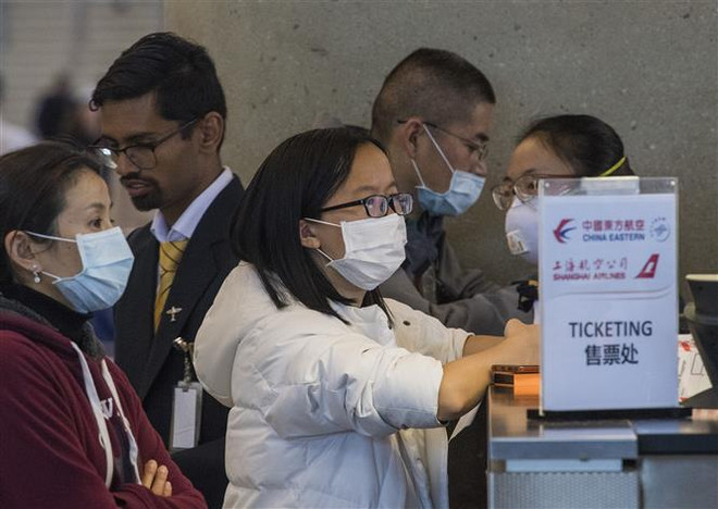 Hành khách đeo khẩu trang đề phòng lây nhiễm COVID-19 tại sân bay quốc tế Los Angeles, bang California, Mỹ. (Ảnh: AFP/TTXVN) Dịch COVID-19: Mỹ sẽ xét nghiệm tất cả những người có triệu chứng cúm ảnh 1