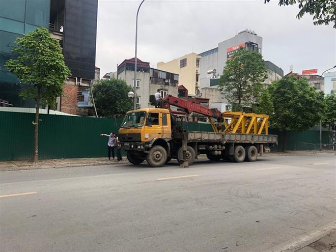 Phương tiện được tập kết tại chân tòa nhà 8B Lê Trực chuẩn bị cho việc tháo dỡ phần vi phạm giai đoạn 2 của tòa nhà. (Ảnh Mạnh Khánh/TTXVN) Kiểm kê vật dụng trước khi phá dỡ tầng 18 tòa nhà 8B Lê Trực ảnh 1