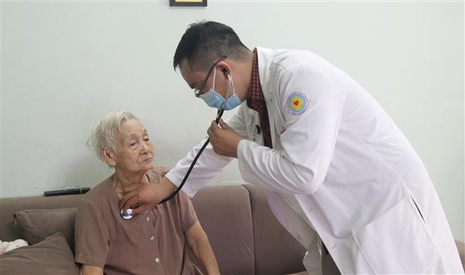 Bác sỹ Bệnh viện Quận 11 Thành phố Hồ Chí Minh khám bệnh tại nhà cho người cao tuổi. (Ảnh: Đinh Hằng/TTXVN) Quan tâm hơn nữa đến sức khỏe của người cao tuổi ảnh 1
