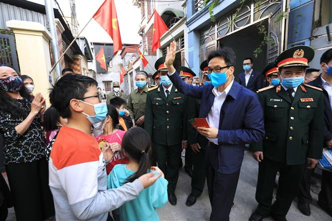 Phó Thủ tướng Vũ Đức Đam với người dân tại tổ dân phố số 10 và 11, nhà máy Z153 - Cục Kỹ thuật, Bộ Quốc phòng (huyện Đông Anh, Hà Nội). (Ảnh: Thành Đạt/TTXVN) Thăm hỏi, động viên các gia đình tại khu tập thể Nhà máy Z153 ảnh 1
