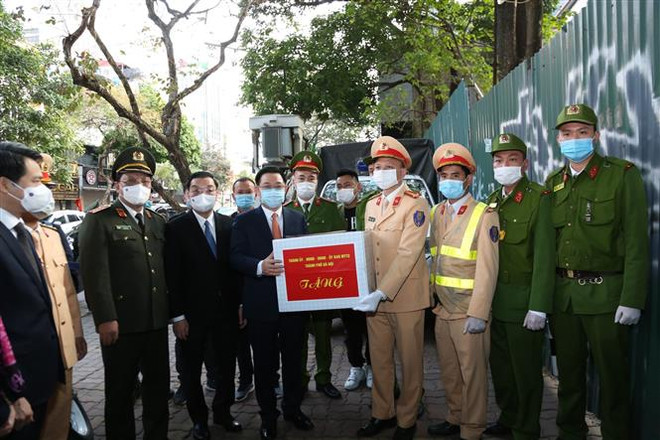 Bí thư Thành ủy Hà Nội Vương Đình Huệ tặng quà động viên cán bộ, chiến sỹ tổ công tác 141 đang làm nhiệm vụ tại ngã tư Trần Hưng Đạo-Hàng Bài (Hà Nội). (Ảnh: Nguyễn Cúc/TTXVN) Công an Hà Nội đảm bảo an ninh trật tự Tết Tân Sửu 2021 ảnh 2