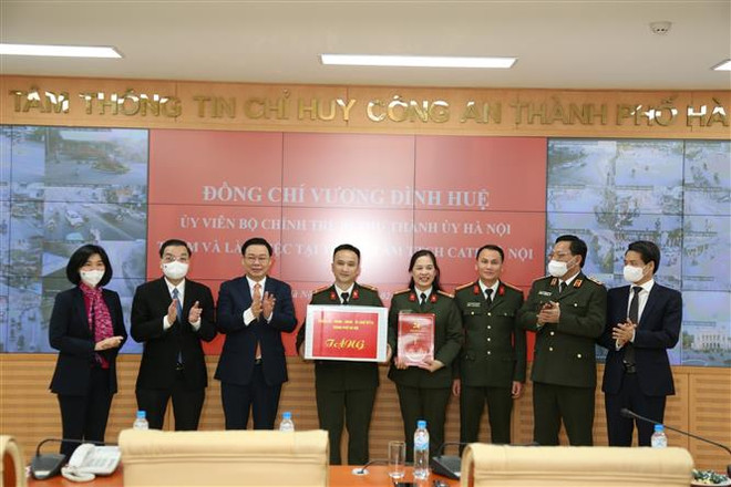 Bí thư Thành ủy Hà Nội Vương Đình Huệ tặng quà các cán bộ, chiến sỹ Trung tâm Thông tin Chỉ huy Công an thành phố Hà Nội. (Ảnh: Nguyễn Cúc/TTXVN) Công an Hà Nội đảm bảo an ninh trật tự Tết Tân Sửu 2021 ảnh 1