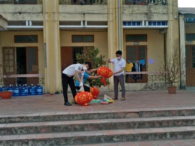 Phụ huynh tất bật trang trí sân trường khu cách ly tại trường tiểu học Lai Cách (huyện Cẩm Giàng) với mong muốn phần nào mang đến không gian Tết vào khu cách ly, đem lại niềm vui cho trẻ. (Ảnh: Mạnh Minh/TTXVN) Hải Dương: Lì xì nhân ái đến với các em nhỏ trong khu cách ly ảnh 1