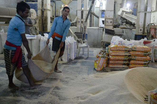 Công nhân vận chuyển gạo tại nhà máy ở Hyderabad, Ấn Độ. (Ảnh: AFP/TTXVN) ttxvn_1407_gao an do.jpg