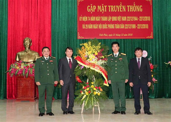 Tổng giám đốc TTXVN Nguyễn Đức Lợi tặng hoa chúc mừng Sư đoàn 304. (Ảnh: Văn Điệp/TTXVN) Phát huy mối quan hệ kết nghĩa tốt đẹp giữa TTXVN và Sư đoàn 304 ảnh 1