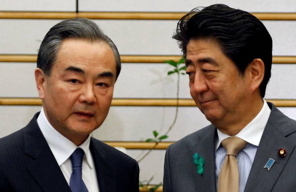 Thủ tướng Nhật Bản Shinzo Abe (phải) tiếp Bộ trưởng Ngoại giao Trung Quốc Vương Nghị. (Nguồn: Reuters) Nhật-Trung muốn đưa quan hệ song phương tới ''một khởi đầu mới'' ảnh 1