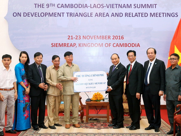 Thủ tướng Nguyễn Xuân Phúc tặng bà con Việt kiều tại Siem Reap 5 tấn gạo. (Ảnh: Thống Nhất/TTXVN) Thủ tướng Nguyễn Xuân Phúc hội kiến Thủ tướng Lào Sisoulith ảnh 2