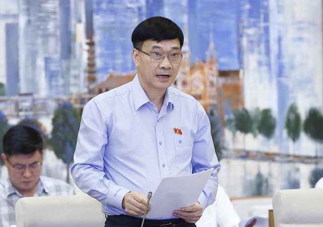 Chủ nhiệm Ủy ban Kinh tế của Quốc hội Vũ Hồng Thanh trình bày báo cáo. (Ảnh: Doãn/TTXVN) Bỏ quy định bắt buộc giao dịch bất động sản thông qua sàn giao dịch ảnh 1