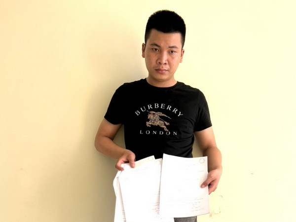 Đối tượng Đinh Văn Trường cùng tang vật vụ việc. (Ảnh: TTXVN phát) Đồng Nai: Khởi tố đối tượng cho vay nặng lãi với lãi suất hơn 304% ảnh 1