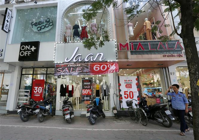 Các cửa hàng giảm giá từ 30-60% trên phố Chùa Bộc. (Ảnh: Hoàng Hiếu/TTXVN) Các tín đồ rộn ràng mua sắm trong ngày ''Thứ Sáu đen tối'' ảnh 1