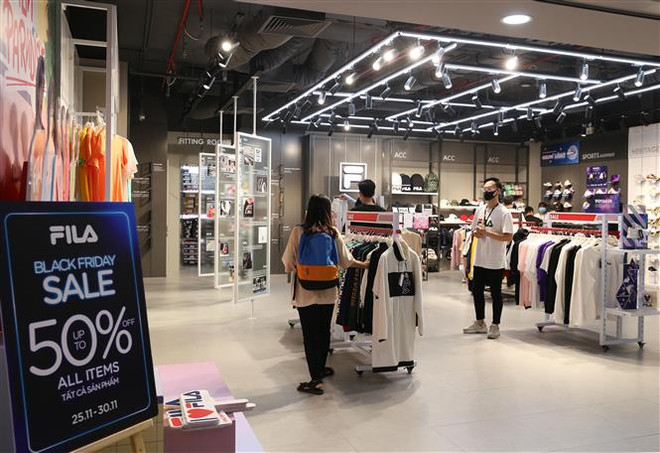 Giảm giá tới 50% để kích cầu tại một cửa hàng trong dịp Black Friday. (Ảnh: Hoàng Hiếu/TTXVN) Các tín đồ rộn ràng mua sắm trong ngày ''Thứ Sáu đen tối'' ảnh 2