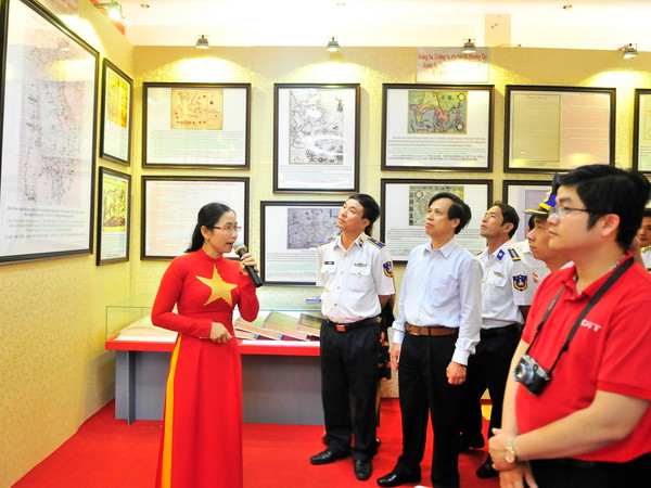 Các đại biểu xem tư liệu trưng bày. (Ảnh: Lê Huy Hải/TTXVN) Triển lãm bản đồ, trưng bày tư liệu Hoàng Sa, Trường Sa ở Phú Quốc ảnh 1