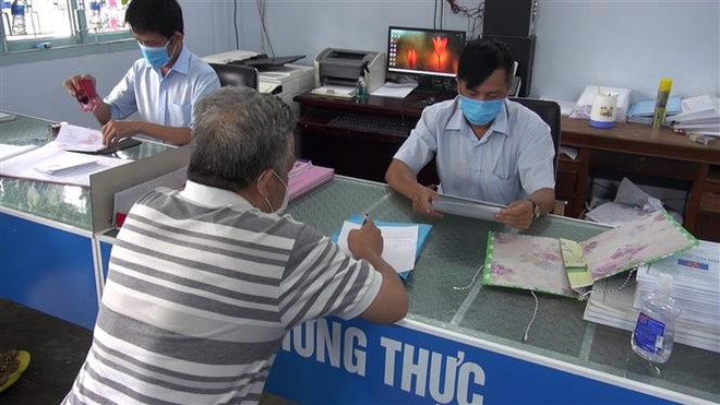 Ông Hồ Minh Kiện chủ quán càphê Mộc nhận quyết định xử phạt vi phạm hành chính tại UBND phường Long Thạnh, Thị xã Tân Châu. (Ảnh: Thanh Sang/TTXVN) Xử phạt nhiều trường hợp vi phạm quy định phòng, chống dịch COVID-19 ảnh 2