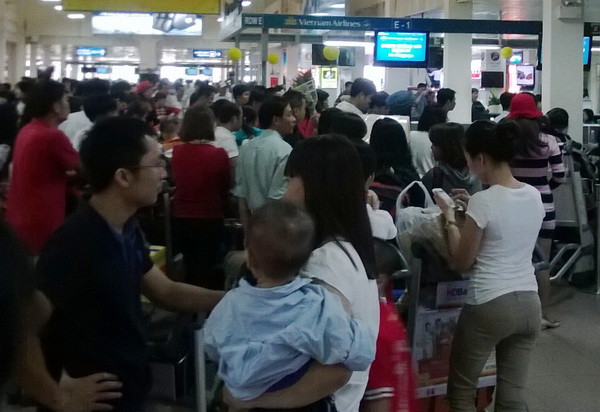Hàng dài người xếp hàng làm thủ tục lên máy bay (Ảnh: Trần Tình/Vietnam+) Sân bay Tân Sơn Nhất, bến xe đông nghịt người về quê ảnh 1