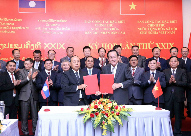 Thượng tướng Võ Minh Lương (phải) Thứ trưởng Bộ Quốc phòng, Trưởng ban Ban Công tác đặc biệt Chính phủ Việt Nam và Thượng tướng Thongloi Silivong (trái), Thứ trưởng Bộ Quốc phòng, Chủ nhiệm Tổng cục Chính trị QĐND Lào, Trưởng ban Ban Công tác đặc biệt Chính phủ Lào ký vào trao đổi Biên bản Kỳ họp. (Ảnh: Xuân Khu/TTXVN) ttxvn_hai cot liet sy o Lao 1.jpg