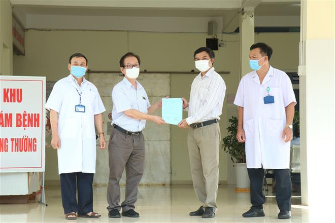 Đại diện ngành y tế Đắk Lắk trao giấy xuất viện cho BN3836. (Ảnh: Tuấn Anh/TTXVN) Đắk Lắk: Tất cả 4 bệnh nhân COVID-19 đều đã được điều trị khỏi ảnh 1