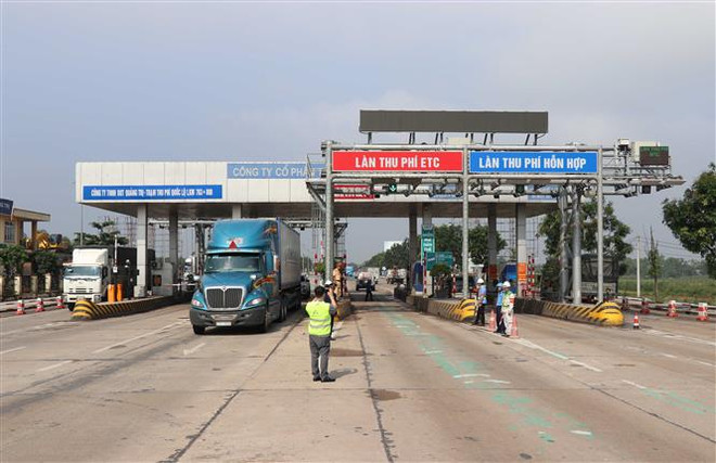 Lực lượng chức năng hướng người điều khiển phương tiện đi đúng làn đường. (Ảnh: Nguyên Lý/TTXVN) Báo cáo Thủ tướng tiến độ triển khai thu phí tự động không dừng ảnh 1