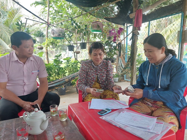 Cán bộ Ngân hàng chính sách xã hội chi nhánh huyện Mỏ Cày Bắc, tỉnh Bến Tre phối hợp các đoàn thể tạo điều kiện cho các học sinh, sinh viên có hoàn cảnh khó khăn vay vốn trang trải chi phí học tập... (Ảnh: Chương Đài/TTXVN) Triển khai hiệu quả nguồn vốn tín dụng chính sách xã hội ở Bến Tre ảnh 1