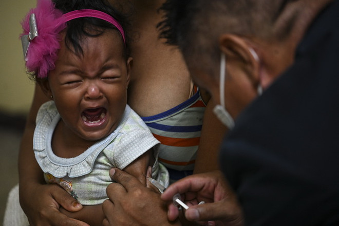 Nhân viên y tế tiêm vaccine ngừa bệnh sởi cho trẻ em tại Caracas, Venezuela. (Ảnh: AFP/TTXVN) Tiêm chủng, một trong những lá chắn đáng tin cậy của nhân loại ảnh 2