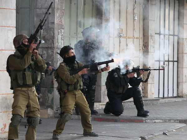 Binh sỹ Israel bắn súng cao su và đạn hơi cay vào người biểu tình bạo động Palestine ở Hebron, Khu Bờ Tây. (Nguồn: AFP/TTXVN) Palestine cảnh báo bước đi đơn phương của Israel ở Bờ Tây ảnh 1