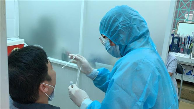 Nhân viên y tế lấy mẫu xét nghiệm. (Ảnh: Đinh Hằng/TTXVN) TP.HCM: 45.000 mẫu xét nghiệm tại các bệnh viện âm tính với SARS-CoV-2 ảnh 1
