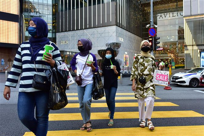 Người dân đeo khẩu trang phòng dịch COVID-19 tại Kuala Lumpur, Malaysia. (Ảnh: THX/TTXVN) Thủ tướng Malaysia công bố Kế hoạch khôi phục quốc gia hậu COVID-19 ảnh 1