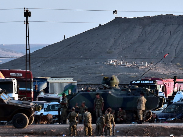 Cờ của phiến quân IS trên đồi Mishtenur, phía Đông thị trấn Kobane, Syria. (Nguồn: AFP/TTXVN) Các chỉ huy quân sự liên minh họp bàn về cuộc chiến chống IS ảnh 1